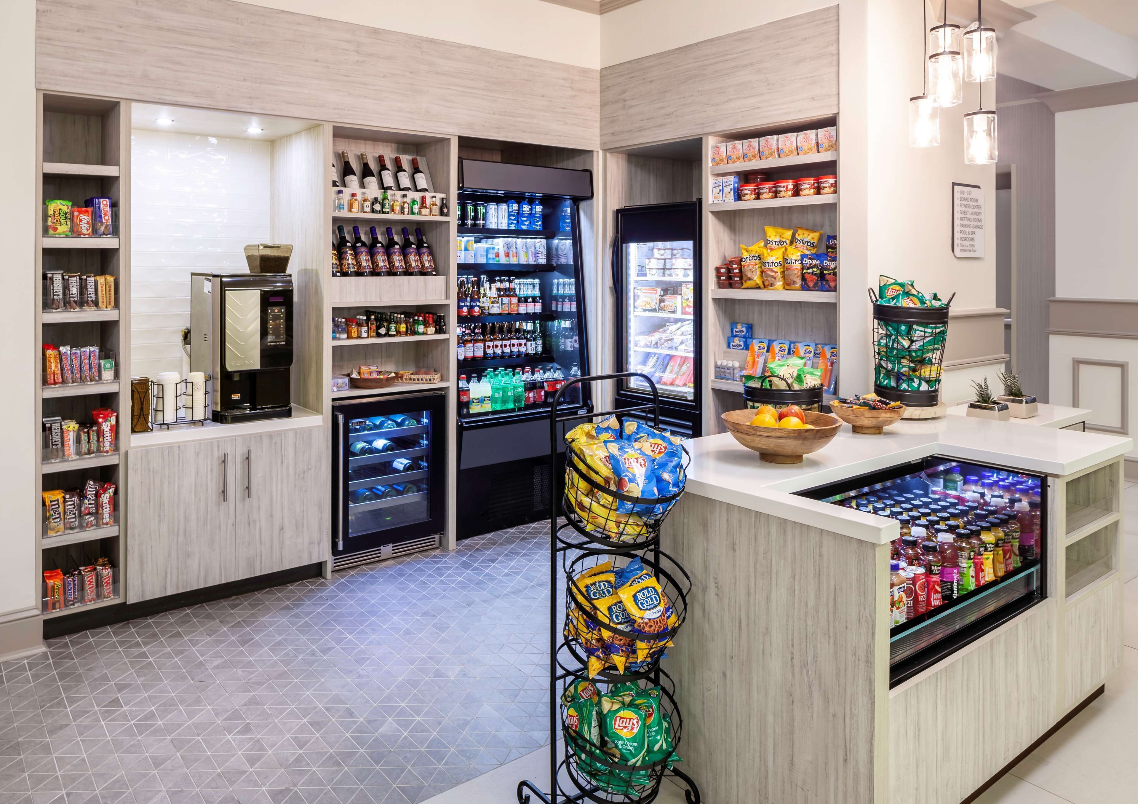 A well-stocked convenience store with shelves of snacks, beverages, and a refrigerated section.