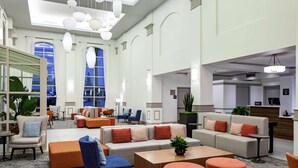 A spacious lobby with high ceilings, modern lighting fixtures, and comfortable seating areas. - Hilton Garden Inn San Diego - Rancho Bernardo (San Diego)