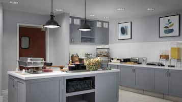 Una cucina moderna con mobili grigi, un'isola centrale, illuminazione a sospensione e un bancone per colazione.