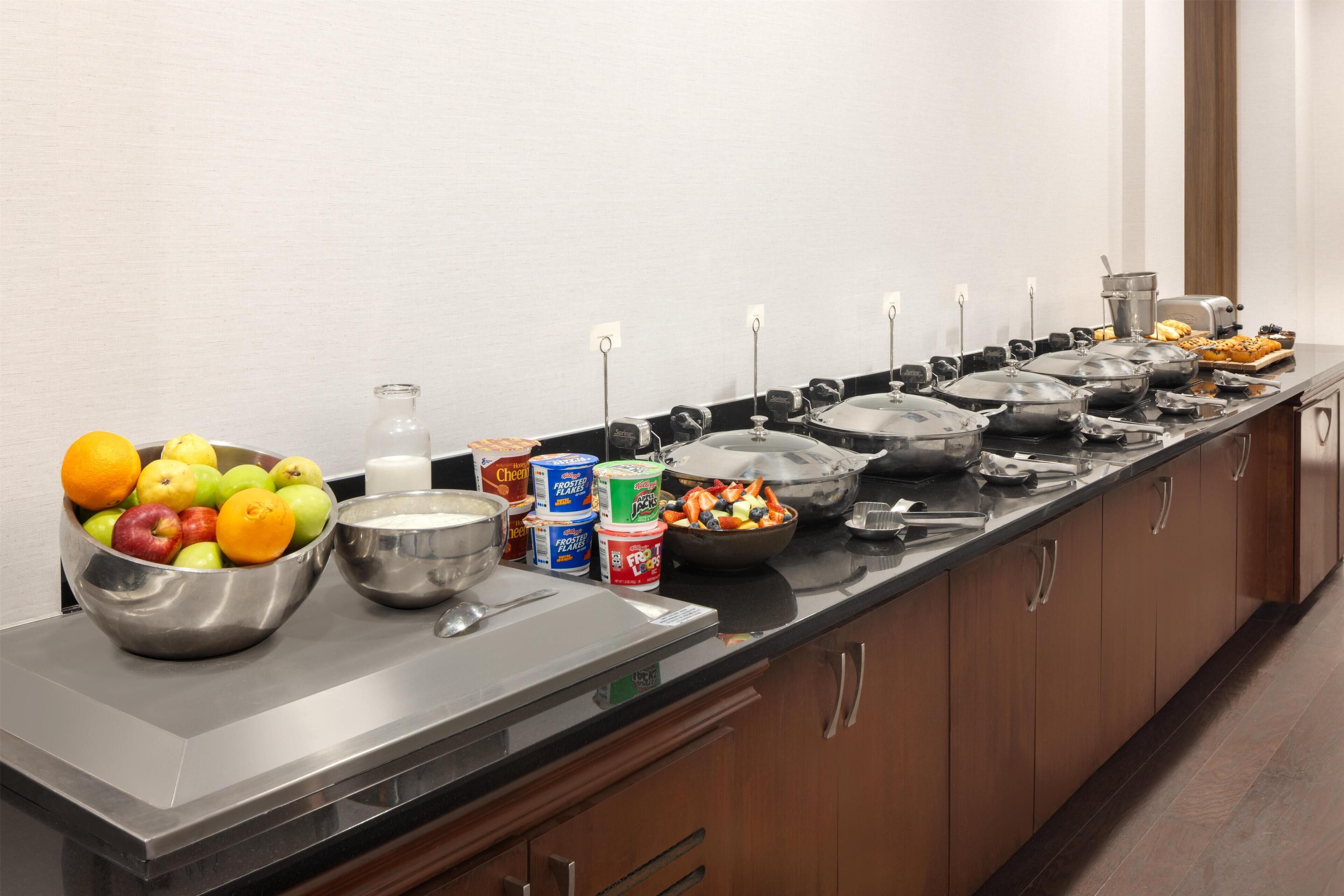 A buffet setup with various food items and containers.