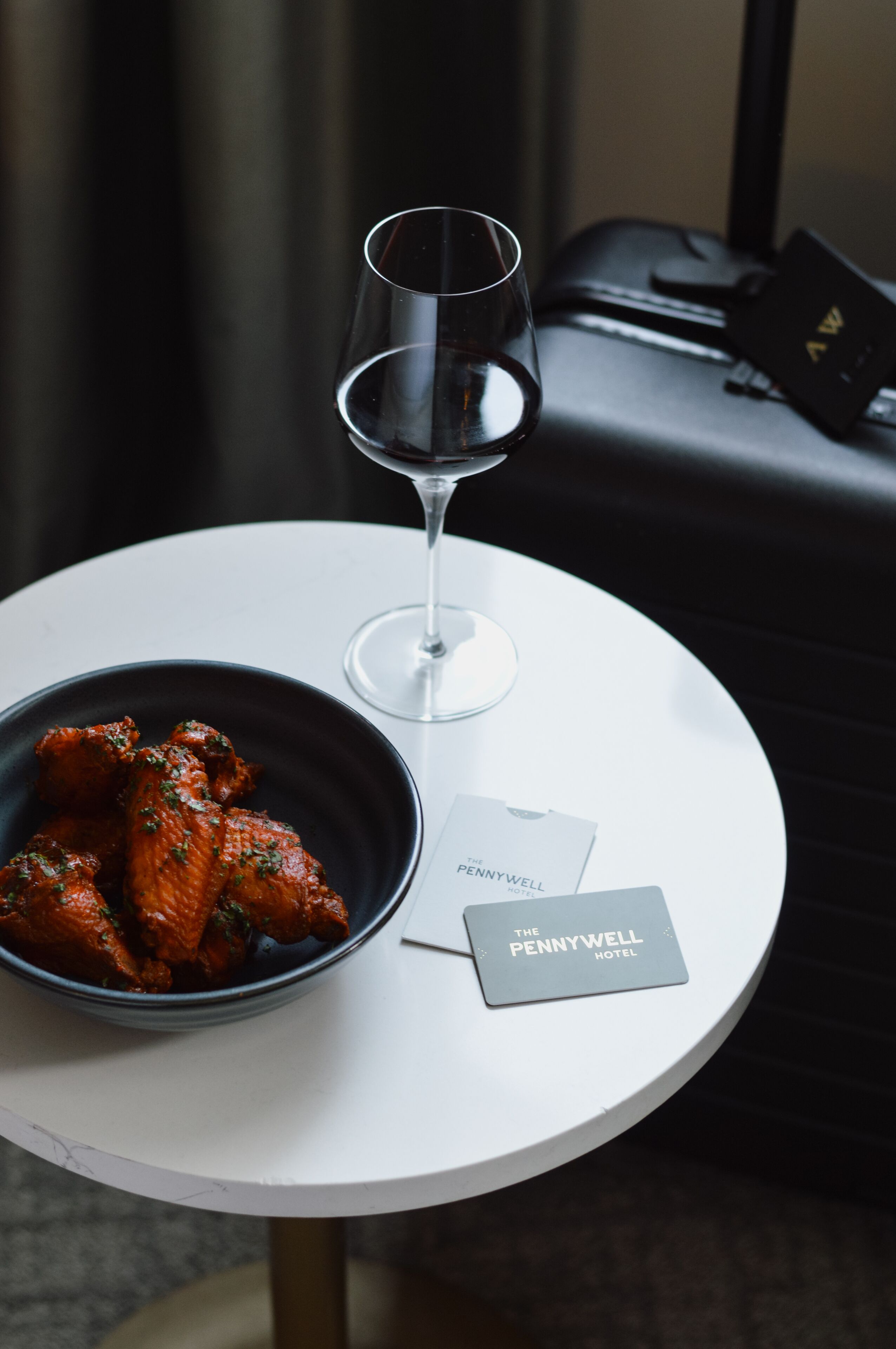 Une table avec un bol de nourriture, un verre à vin et une carte de l’hôtel.