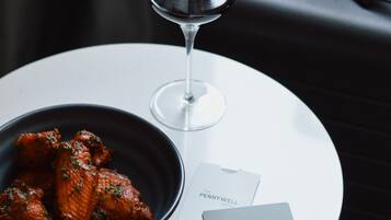 Une table avec un bol de nourriture, un verre à vin et une carte de l’hôtel.