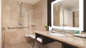 A modern bathroom with a shower, a sink, and a large mirror.