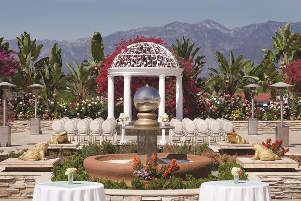 A garden with a gazebo, fountain, and seating area with chairs. - Hilton Los Angeles/San Gabriel (San Gabriel)