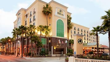 A multi-story hotel with a prominent Hilton sign, featuring a classic architectural style with arched windows and a large entrance.
