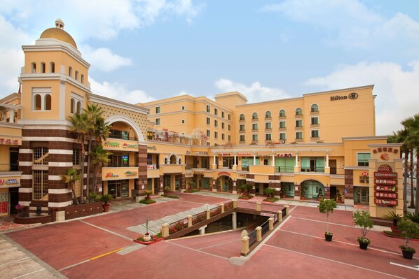 Un hotel con patio central, varios niveles y un llamativo letrero Hilton.