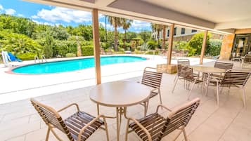 Una piscina al aire libre, sillones reclinables de piscina