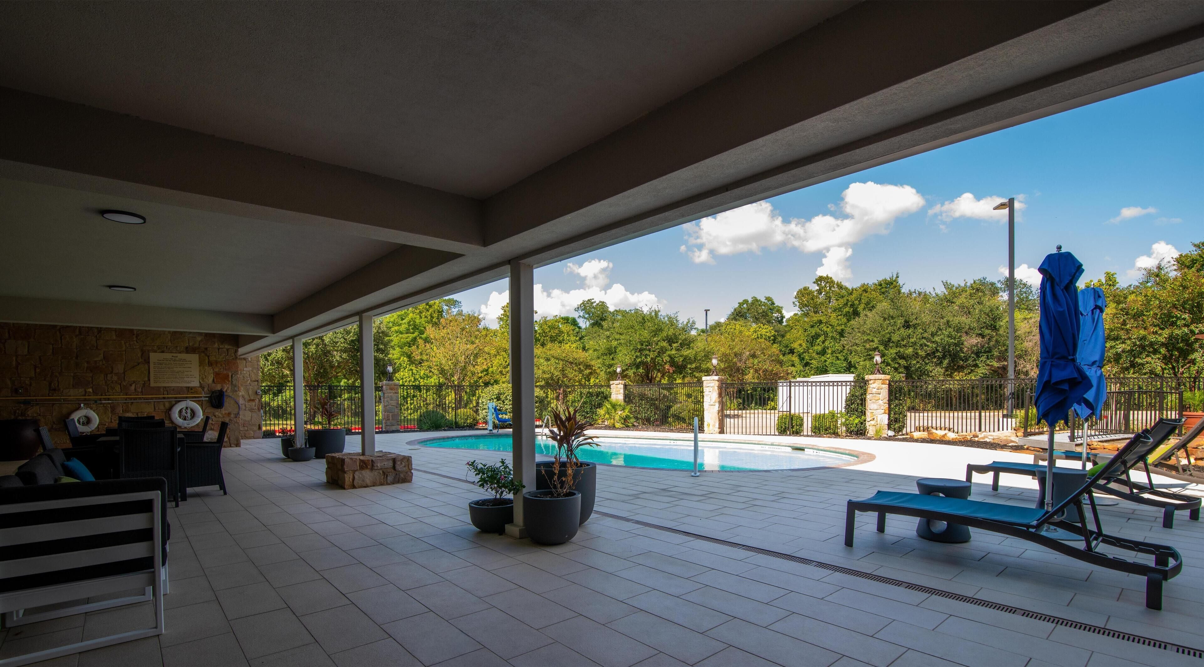 Una piscina al aire libre, sillones reclinables de piscina