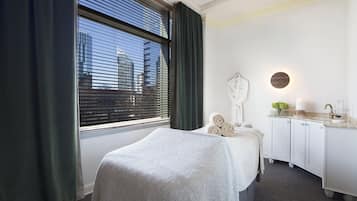 Relax in a serene space with a neatly made bed, bedside table, and wardrobe.
