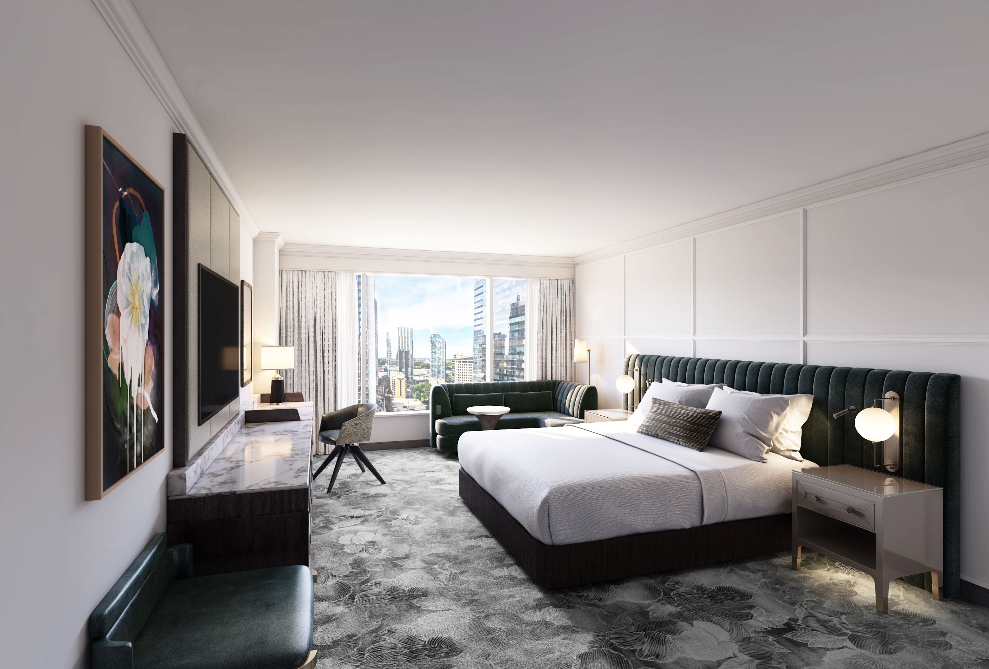 Habitación de hotel moderna con una cama grande, un escritorio, una silla y vistas del horizonte de la ciudad.