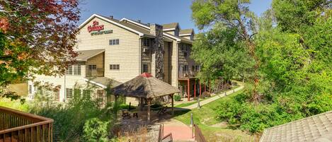 A building with a sign reading "The Cottages" and a covered outdoor seating area.