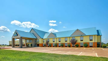 A Days Inn with a covered parking area and a grassy lawn in front.