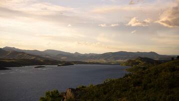 A panoramic view of a lake surrounded by mountains and hills.