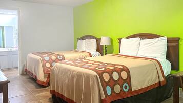 Une chambre d’hôtel avec deux lits, une fenêtre et un mur vert.