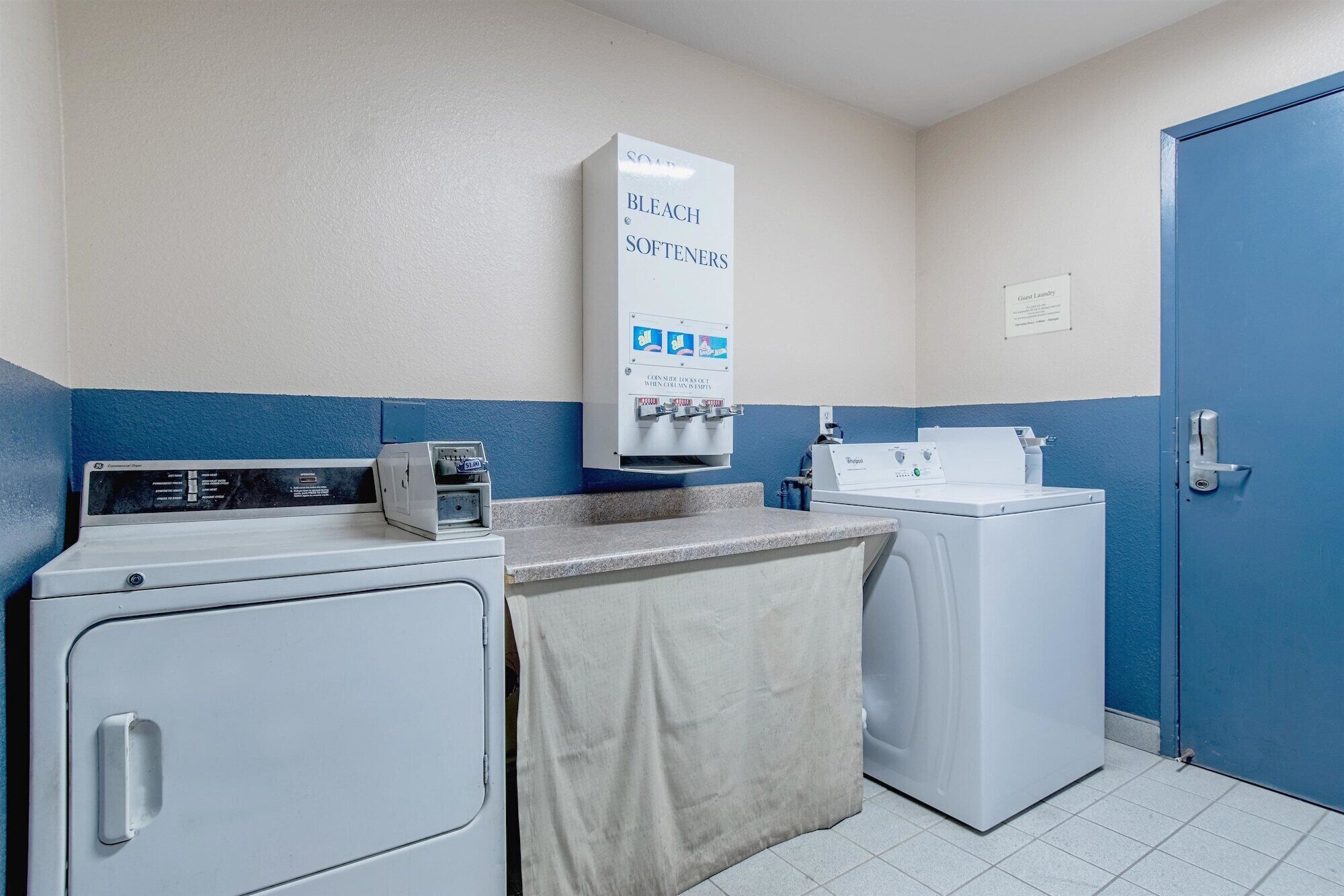 A laundry facility with a washing machine, a dryer, and a soap dispenser.