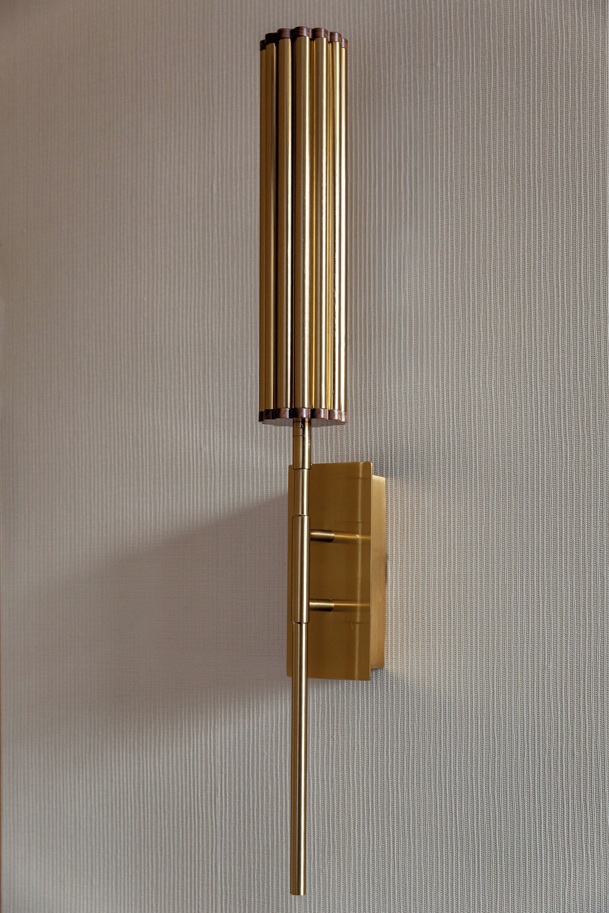 A wall-mounted light fixture with a cylindrical design and a rectangular base.