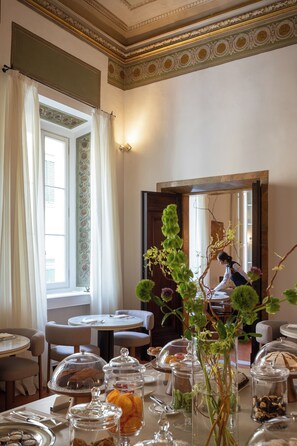 A dining area with tables, chairs, and a view of a cityscape through a window.