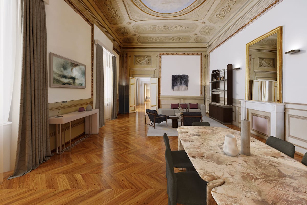 Une pièce spacieuse avec un plancher en bois, une table en marbre et un grand miroir. On aperçoit un canapé et un fauteuil au fond de la pièce.