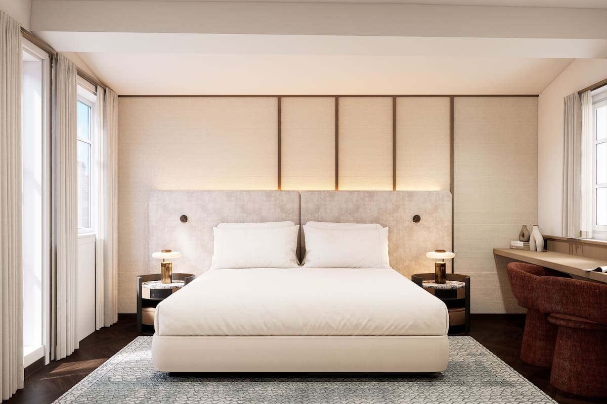 Une chambre moderne avec un grand lit, des tables de chevet, un bureau et une chaise.