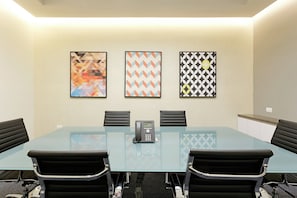 A conference room with a glass table, four black chairs, a telephone, and three framed artworks on the wall. - Holiday Inn Express Villahermosa Tabasco 2000 by IHG (Villahermosa)