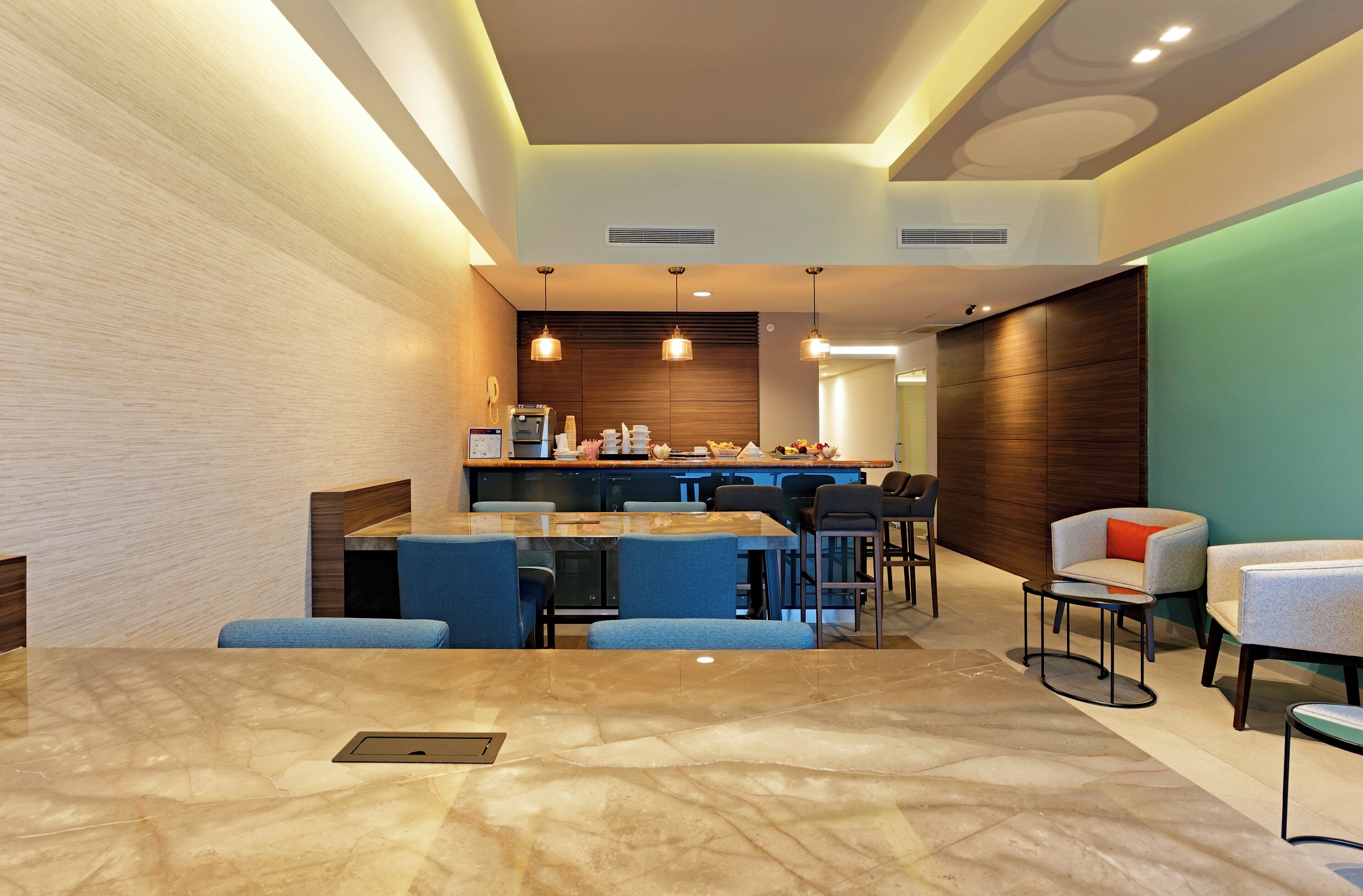 A modern hotel lobby with a marble floor, a bar area, and seating arrangements.