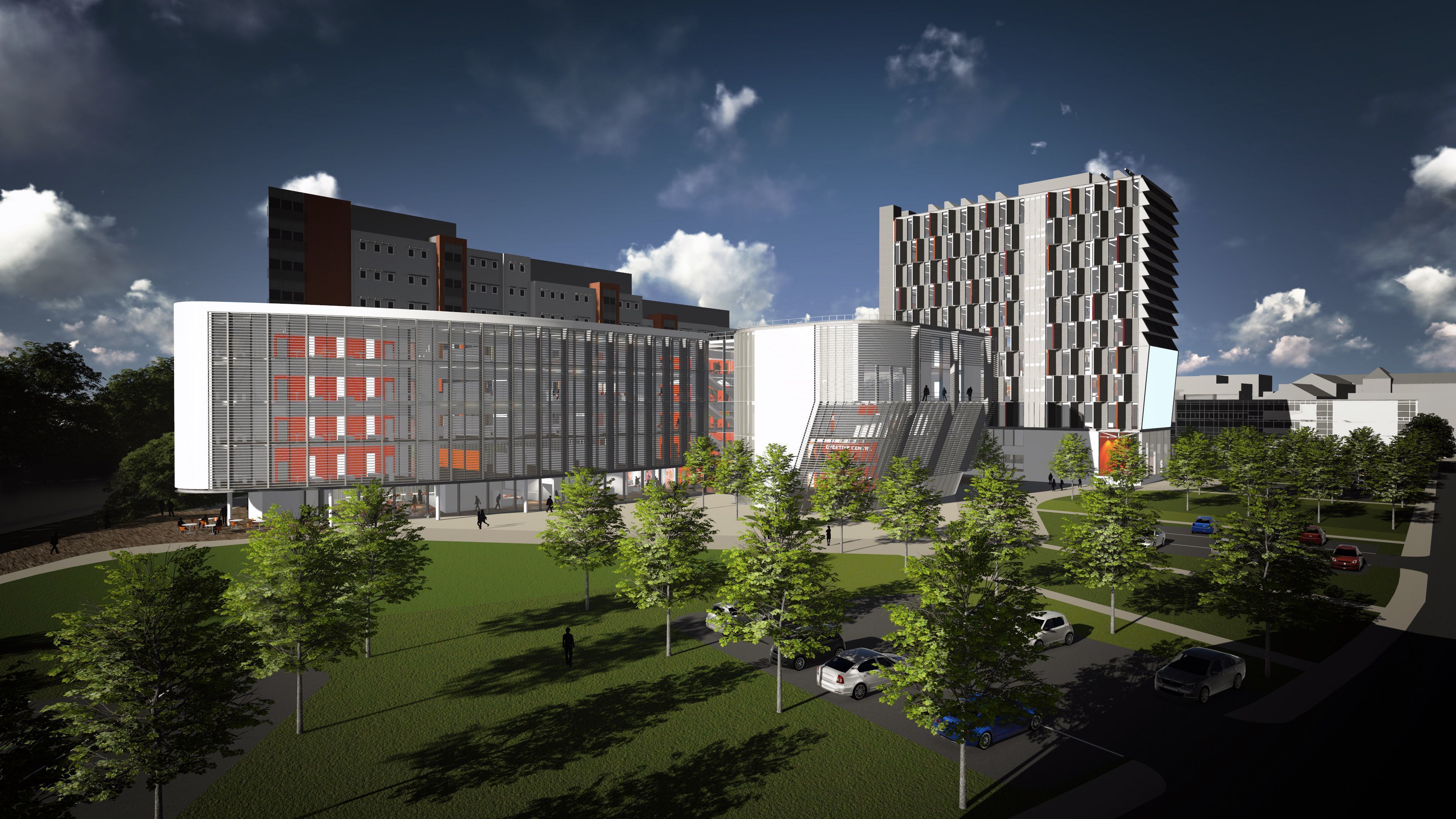 A modern building complex with multiple floors, large windows, and a central courtyard with trees and parked cars.