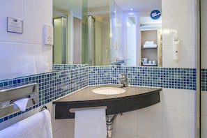A modern bathroom with a granite sink, a mirror, and a towel rack. - Holiday Inn Express Leicester - City by IHG (Leicester)