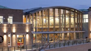 A modern building with a glass facade, a brick exterior, and a sign indicating it is part of the University of Leicester. - Holiday Inn Express Leicester - City by IHG (Leicester)