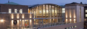 A modern building with a glass facade, a brick exterior, and a sign indicating it is part of the University of Leicester.