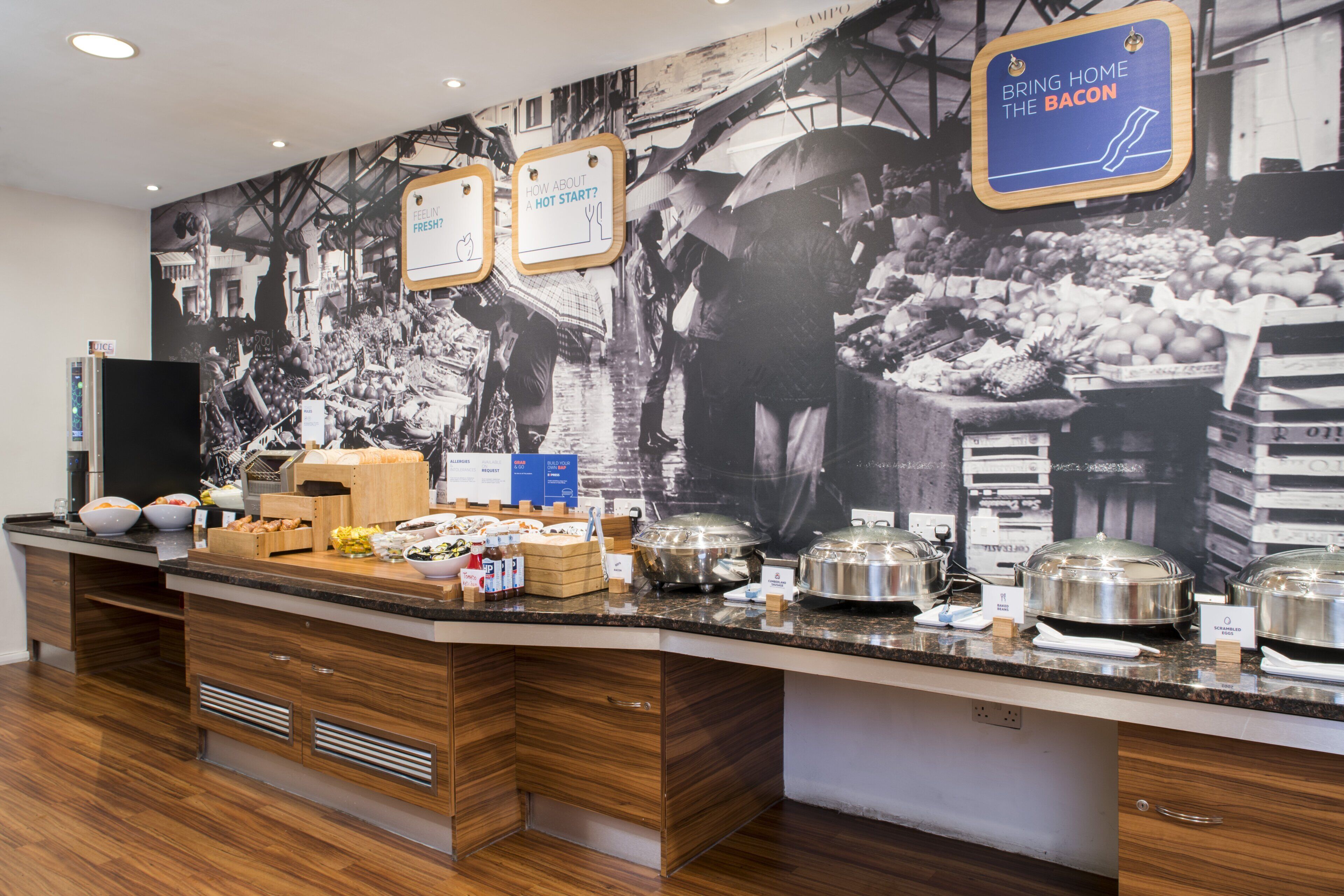 A buffet area with various food items and a large wall mural.