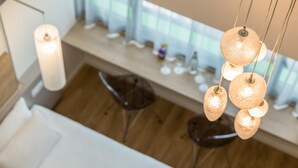 Een moderne keuken met hangende吊り下げlichten, een houten vloer en een wit aanrecht.
