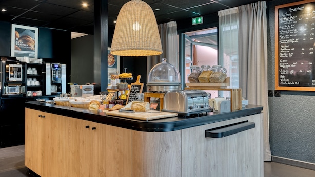 A breakfast bar with a coffee machine, toaster, and various food items.
