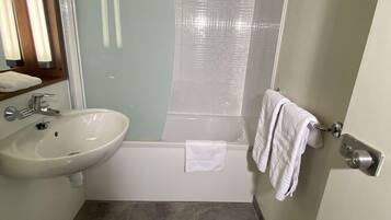Een badkamer met wastafel, toilet en bad.