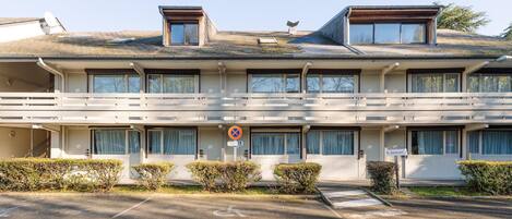 Un edificio de varios pisos con techo plano, ventanas grandes y un letrero que indica un restaurante.