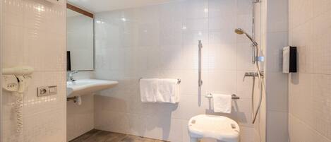 Une salle de bain moderne équipée d’une douche, d’un lavabo et de toilettes.