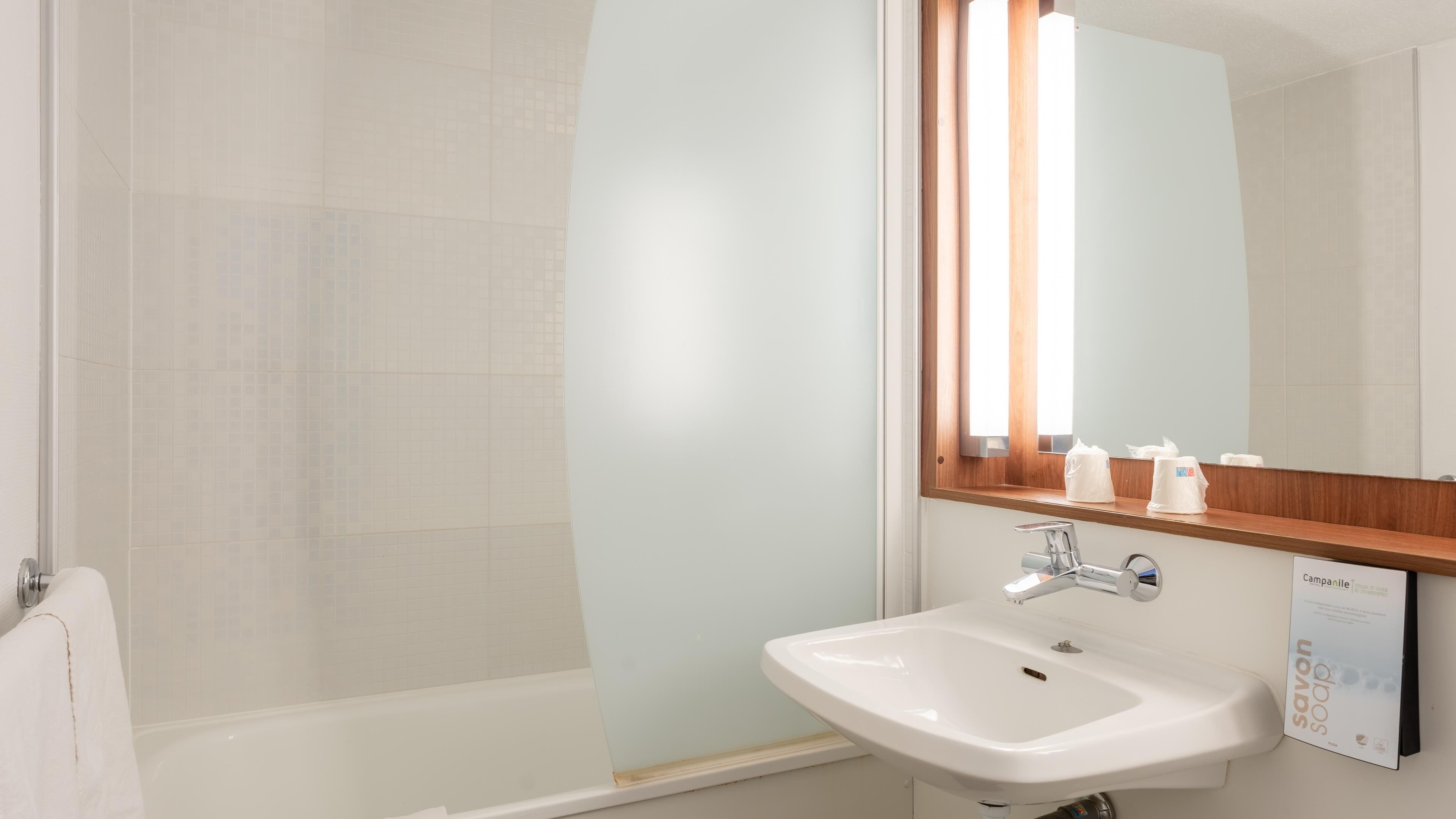 Une salle de bain moderne avec une douche, un lavabo et un miroir.
