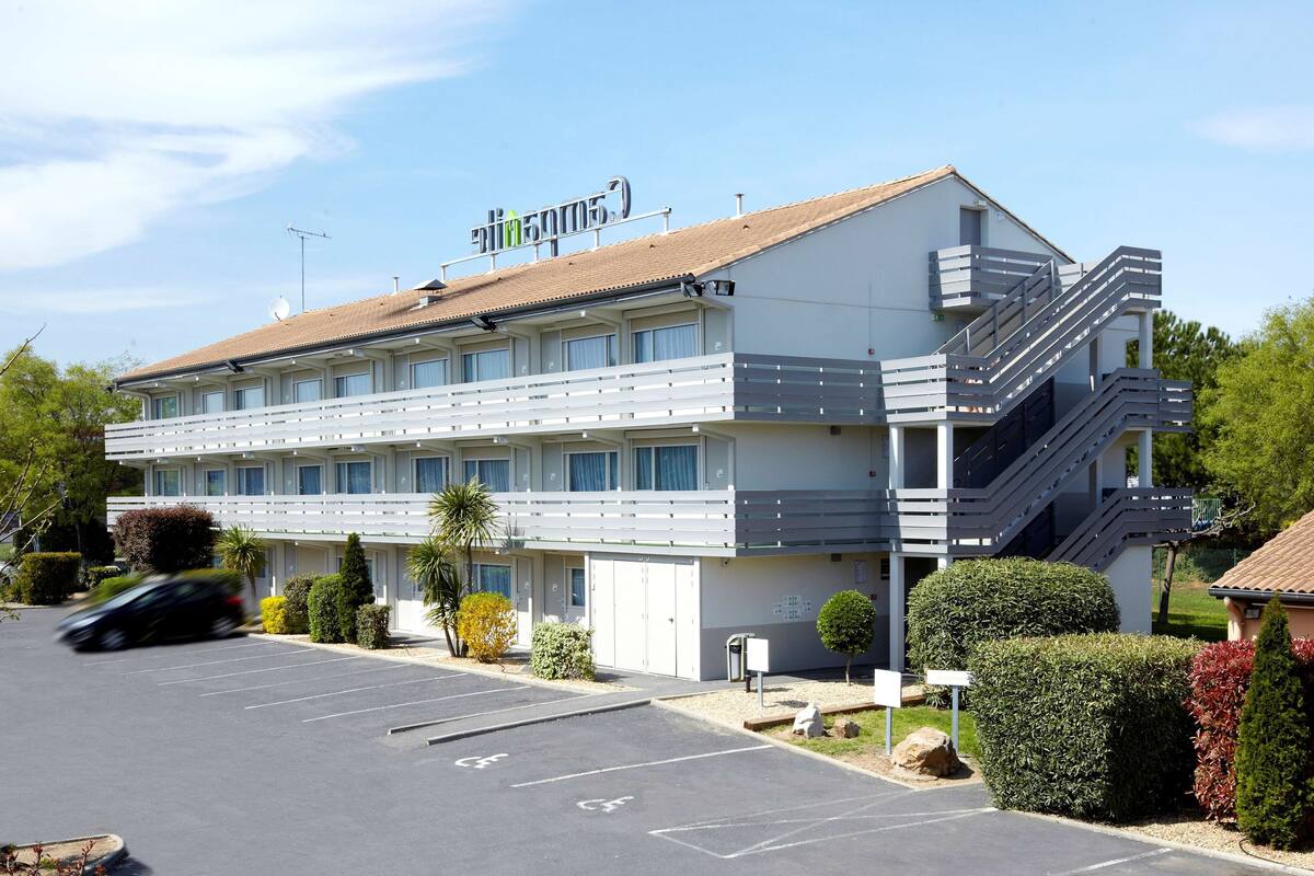 Un hôtel moderne doté d’un toit plat, de nombreux balcons et d’un parking.
