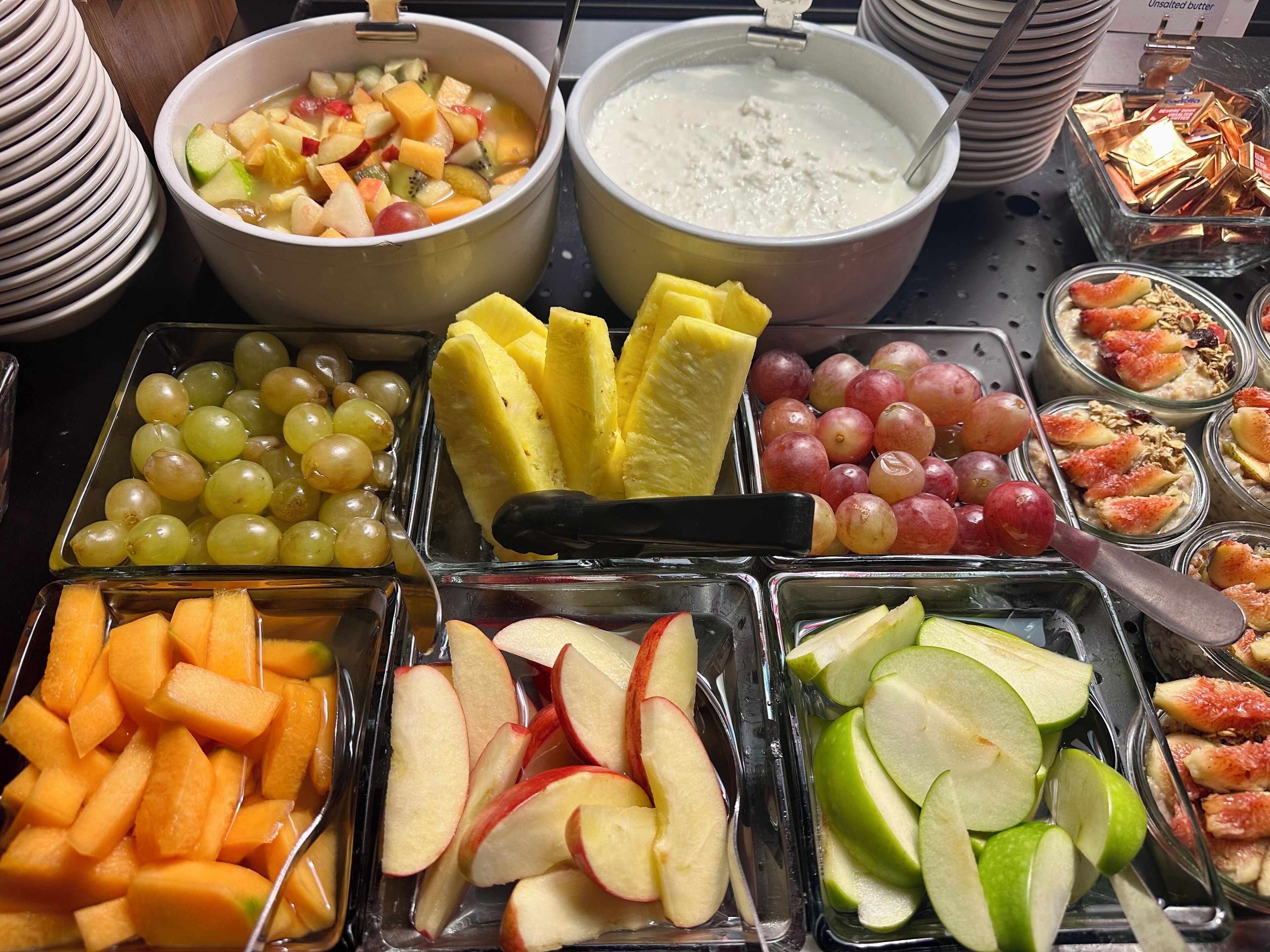 Buffet com diversas frutas, legumes e sobremesas.