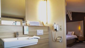 Ein Badezimmer mit Waschbecken, Spiegel, Toilettenartikeln und einem Telefon.