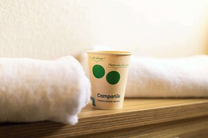Una taza de papel con un logo y texto sobre una superficie de madera.