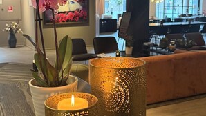 A reception area with a potted orchid, two decorative candle holders, and a reception desk. - Best Western Hotel Trollhattan (Trollhattan)
