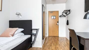 Une chambre moderne comprenant un lit, une table de chevet, une lampe et un bureau avec une chaise.