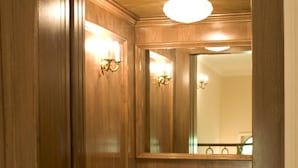 A wooden interior with a mirror, light fixture, and a door with a lock. - Hotel Quinta de los Cedros (Madrid)