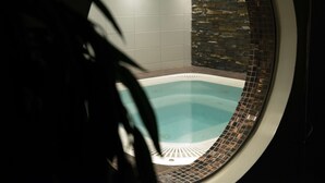 A circular view of a hot tub with a stone wall and tiled floor. - Scandic Karlstad City (Karlstad)