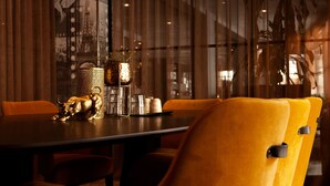 A dining area with a table set for two, featuring a decorative bull figurine, a glass pitcher, and salt and pepper shakers. - Scandic Karlstad City (Karlstad)