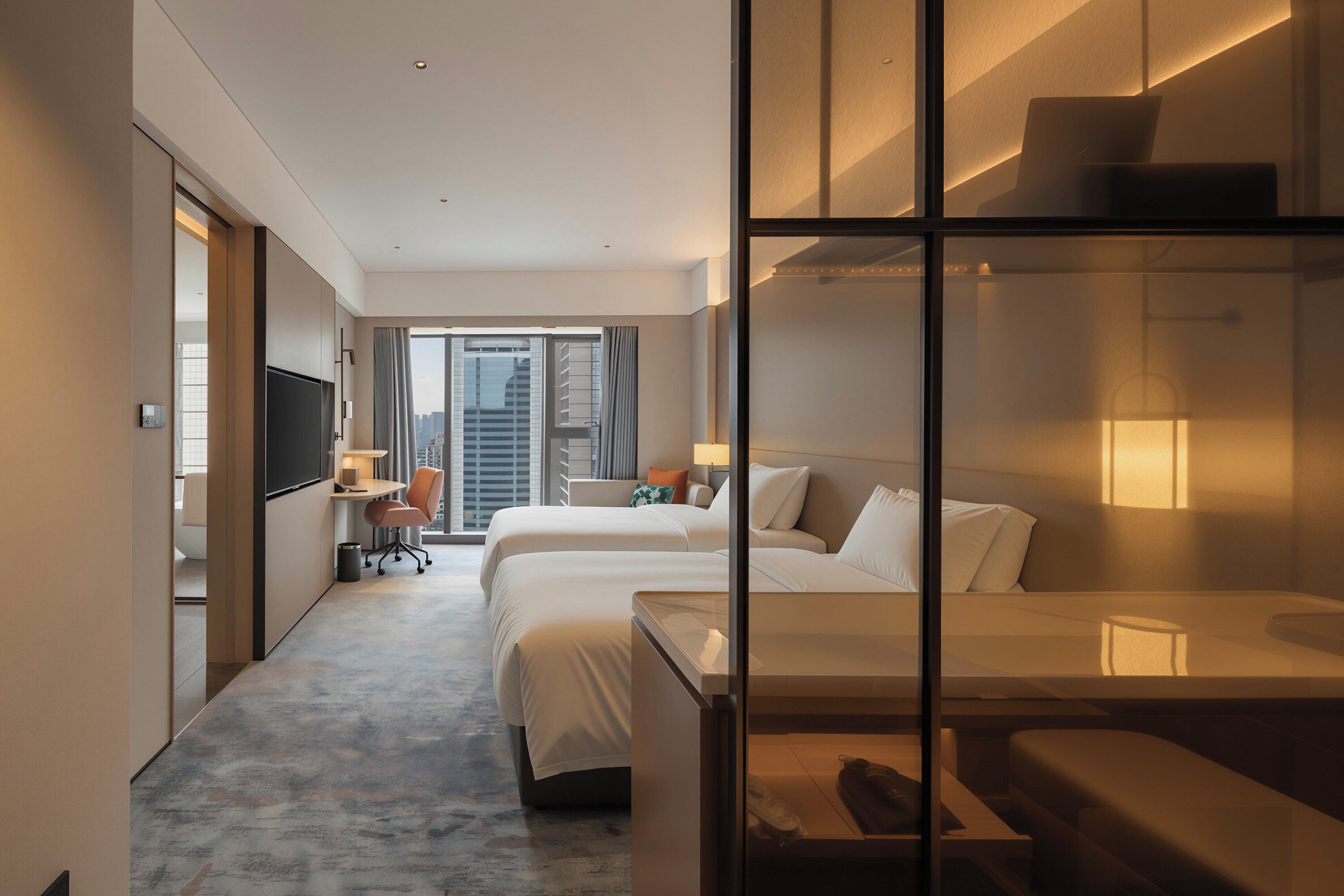 Une chambre d’hôtel avec un grand lit, un bureau, une chaise et un téléviseur.