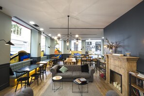 A modern interior with a sofa, dining area, and fireplace. - Petit Palace Triball (Madrid)