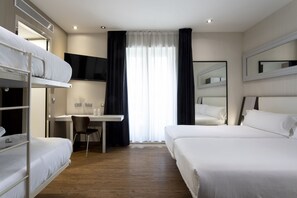 A hotel room with bunk beds, a desk, a chair, a TV, and a large mirror. - Petit Palace Triball (Madrid)