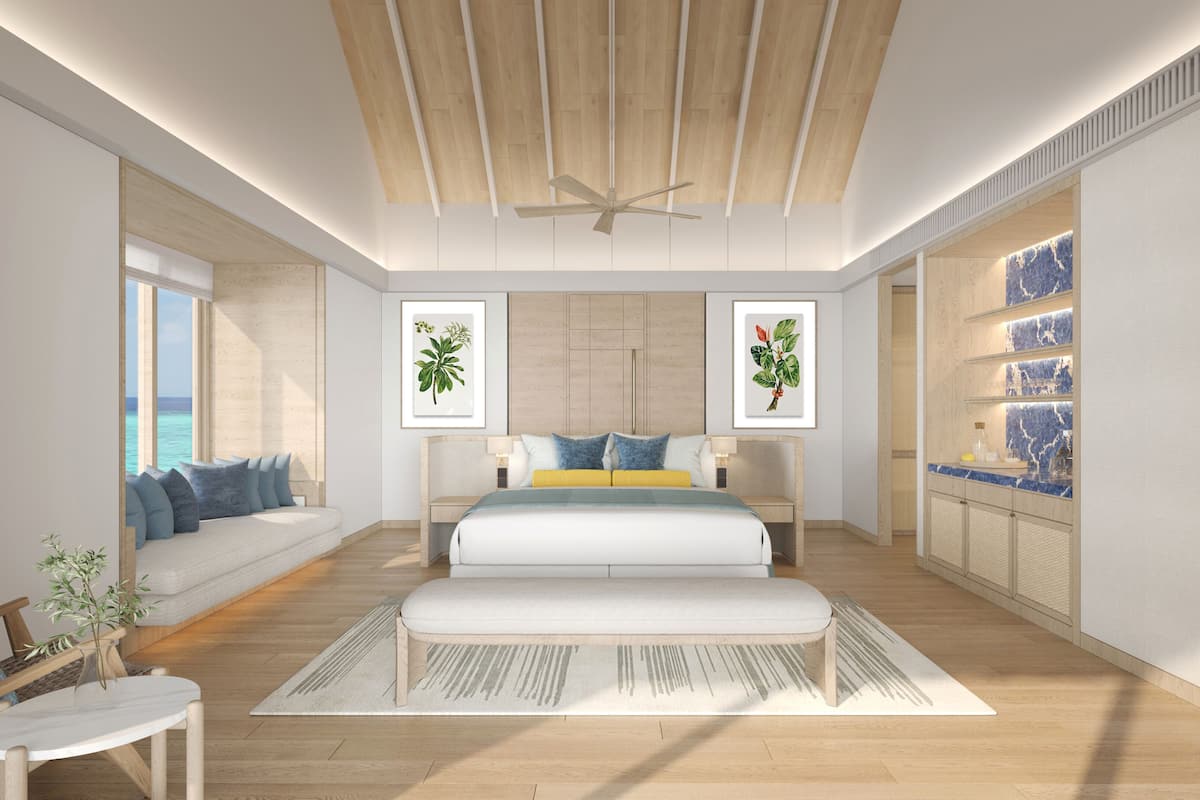 Un dormitorio moderno con una cama grande, un ventilador de techo y vista al océano.