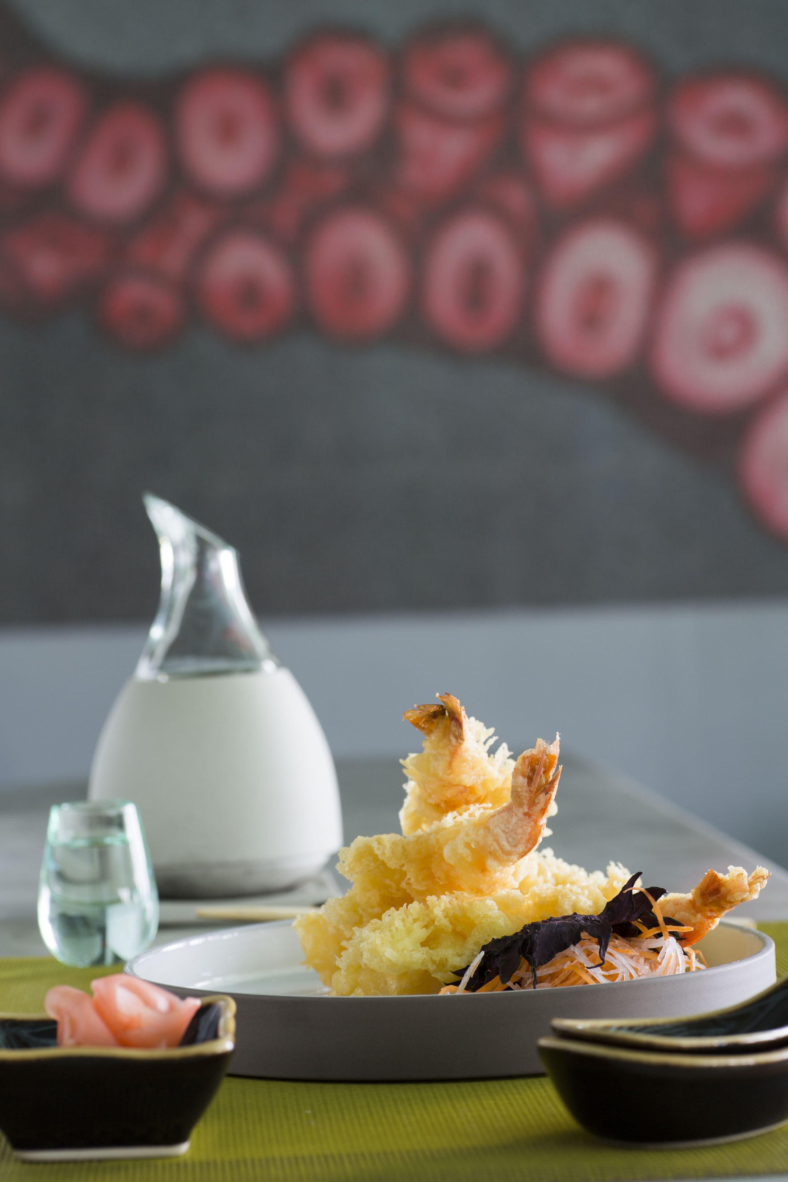 A plate of tempura with a bowl of soy sauce and a small dish of pickled ginger.
